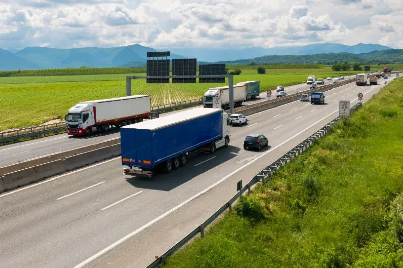 Veículos passando por uma rodovia, representando a tabela de frete da ANTT.